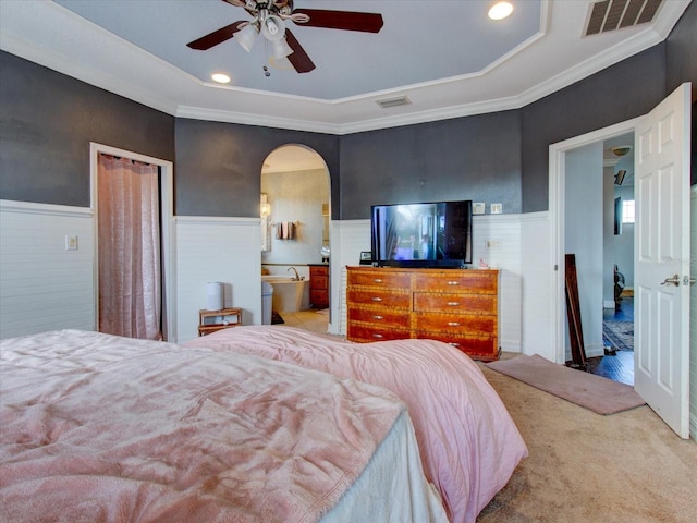 carpeted bedroom featuring ceiling fan, connected bathroom, ornamental molding, a raised ceiling, and a closet