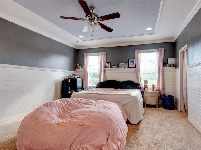 carpeted bedroom with ornamental molding and ceiling fan