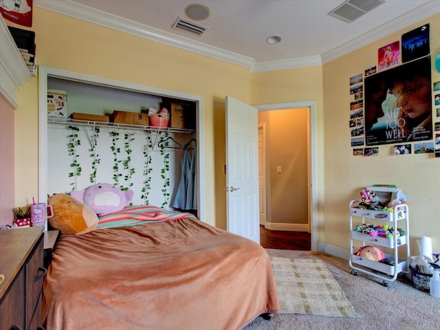 carpeted bedroom with crown molding and a closet