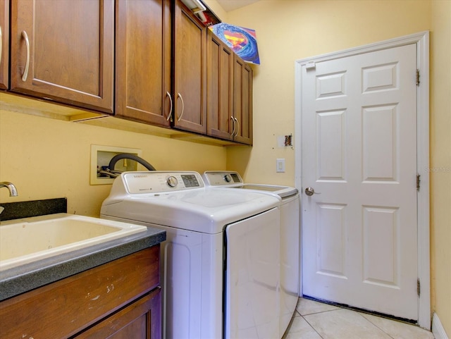 laundry area with light tile patterned flooring, cabinets, separate washer and dryer, and sink