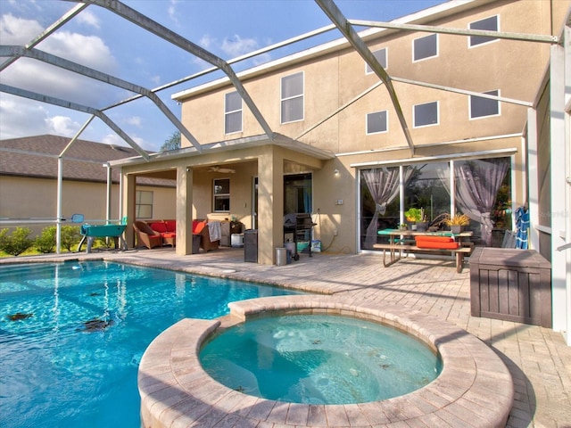 view of pool with ceiling fan, a patio, glass enclosure, an outdoor living space, and an in ground hot tub