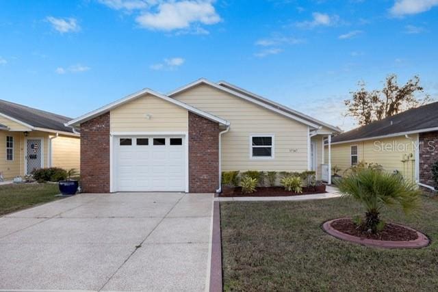 single story home featuring a garage and a front lawn