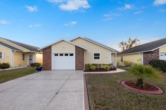 ranch-style home featuring a garage and a front lawn