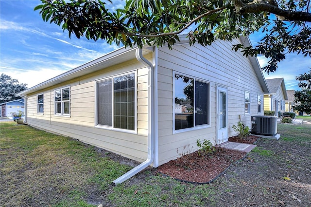 view of home's exterior with central AC unit and a yard