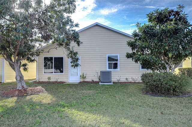 back of property featuring a yard and central air condition unit