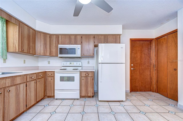 kitchen featuring ceiling fan, a textured ceiling, and white appliances