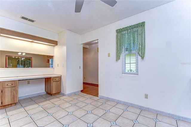 interior space featuring built in desk and ceiling fan