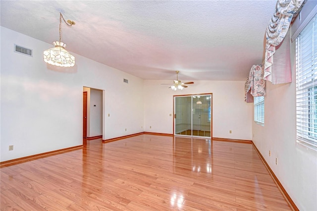 unfurnished room with ceiling fan, vaulted ceiling, light hardwood / wood-style flooring, and a textured ceiling