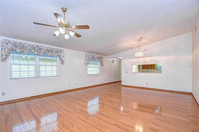 unfurnished living room featuring lofted ceiling, ceiling fan, light hardwood / wood-style flooring, and a textured ceiling