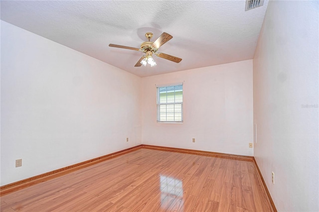 empty room with a textured ceiling, ceiling fan, and light wood-type flooring