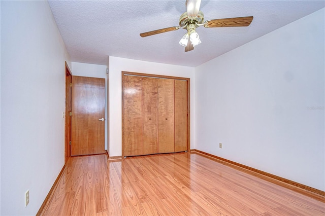 unfurnished bedroom with a closet, ceiling fan, a textured ceiling, and light hardwood / wood-style flooring