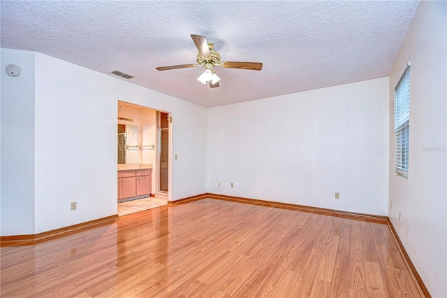 empty room with ceiling fan, a textured ceiling, and light hardwood / wood-style flooring