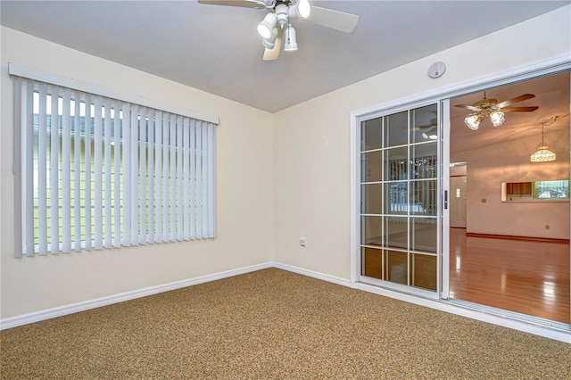 carpeted spare room featuring ceiling fan