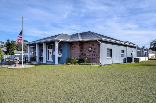 view of front of property featuring central AC unit, a front lawn, and glass enclosure