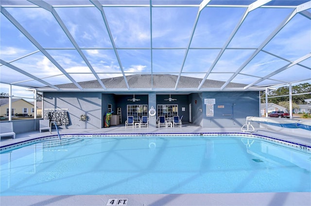 view of swimming pool featuring ceiling fan, a lanai, and a patio