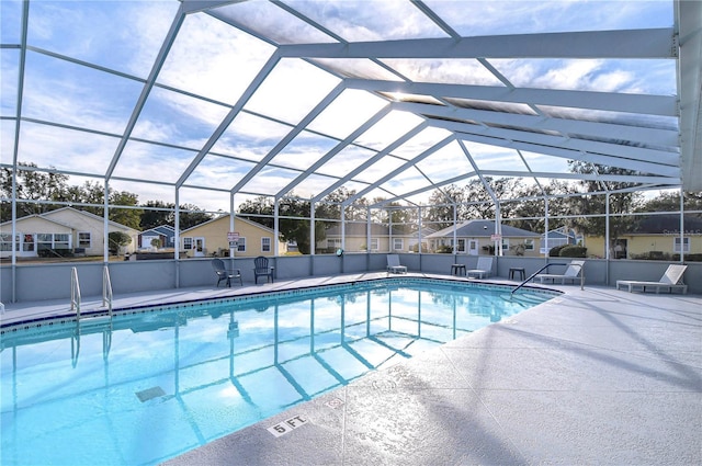 view of pool with a patio area and glass enclosure