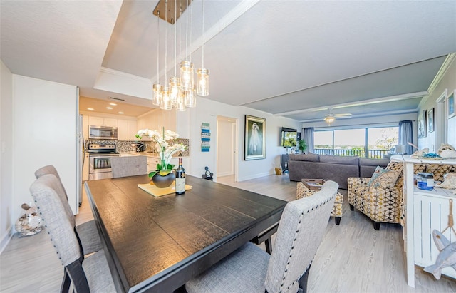 dining space featuring ceiling fan with notable chandelier and light wood-type flooring