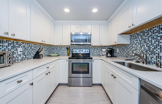 kitchen featuring white cabinetry, sink, and appliances with stainless steel finishes