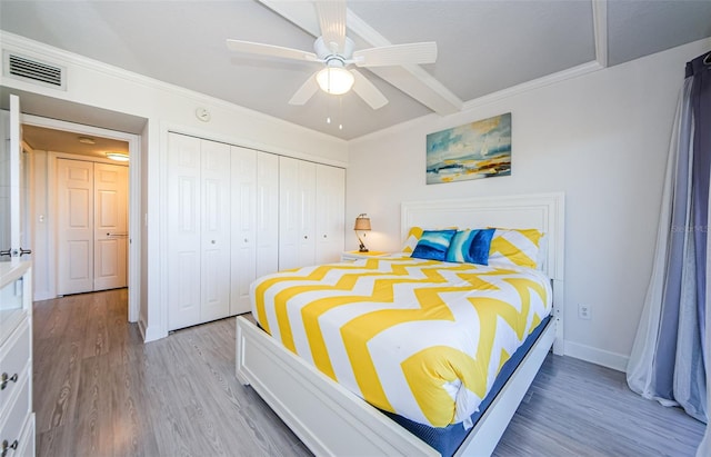 bedroom featuring crown molding, hardwood / wood-style floors, ceiling fan, and a closet