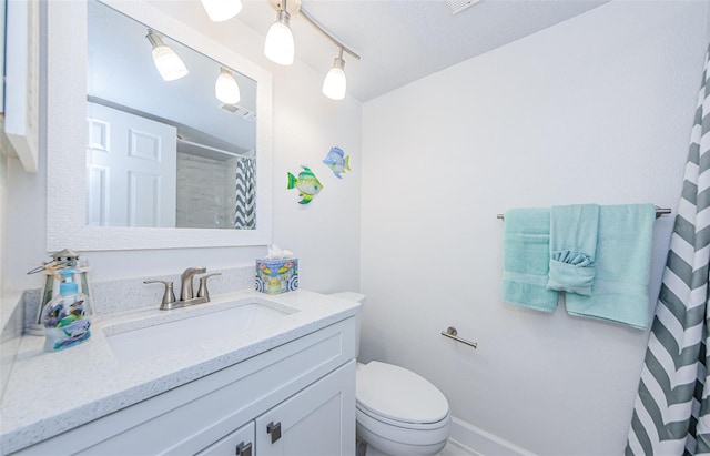 bathroom featuring vanity, curtained shower, and toilet