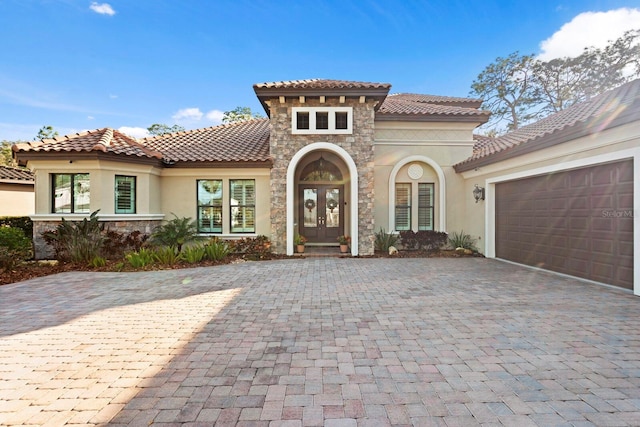 mediterranean / spanish-style home featuring a garage and french doors