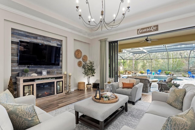 living room with ceiling fan, ornamental molding, and light wood-type flooring