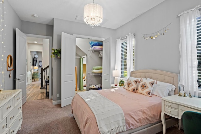 carpeted bedroom featuring a closet and a notable chandelier