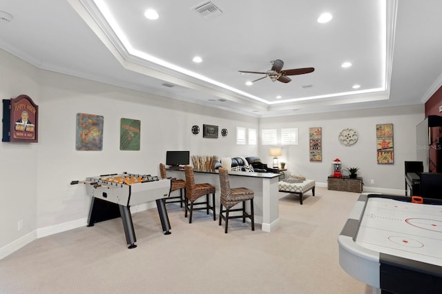 rec room featuring light carpet, ornamental molding, a raised ceiling, and ceiling fan