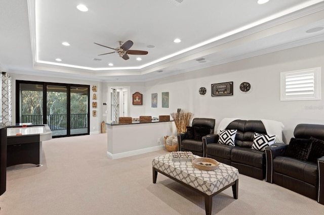 carpeted living room featuring a raised ceiling, crown molding, and ceiling fan