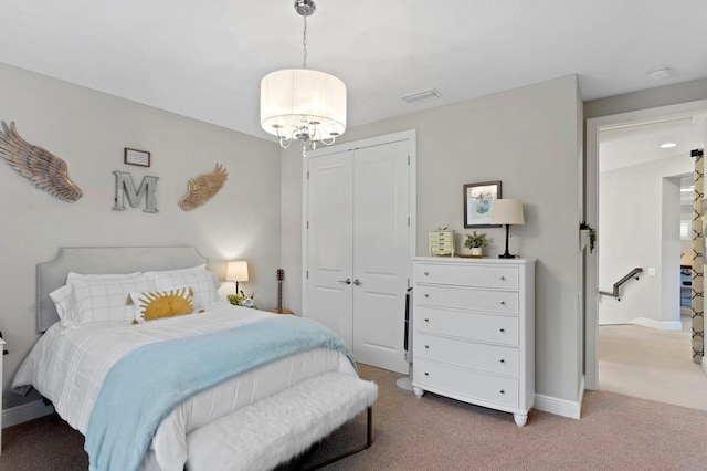 carpeted bedroom featuring a notable chandelier and a closet