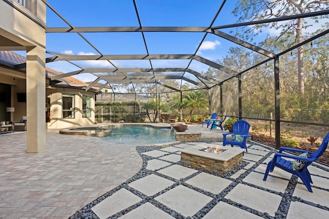 view of swimming pool with pool water feature, a patio, glass enclosure, and an outdoor fire pit