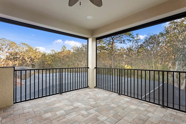 unfurnished sunroom featuring ceiling fan