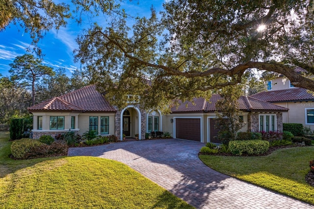 mediterranean / spanish home with a garage and a front yard