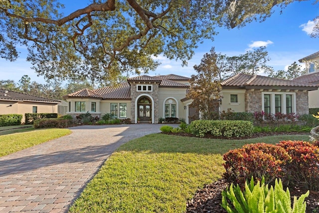 mediterranean / spanish-style home featuring a front lawn