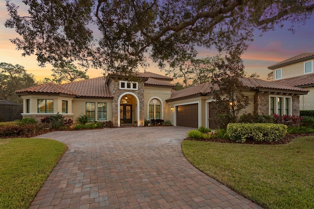 mediterranean / spanish-style home with a garage and a lawn