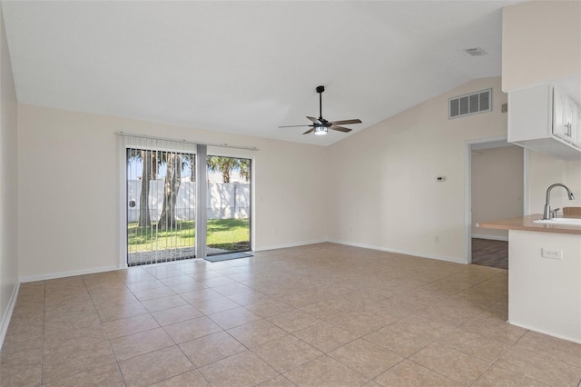 unfurnished living room featuring light tile patterned flooring, ceiling fan, lofted ceiling, and sink