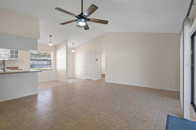 unfurnished living room with light tile patterned flooring, lofted ceiling, a textured ceiling, and ceiling fan