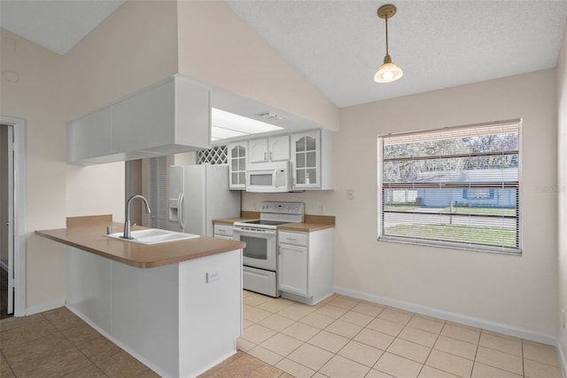 kitchen featuring pendant lighting, white cabinetry, sink, kitchen peninsula, and white appliances