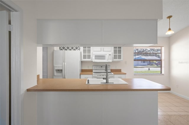 kitchen with sink, white appliances, white cabinets, decorative light fixtures, and kitchen peninsula