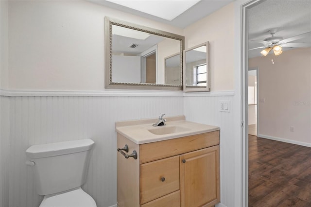 bathroom with vanity, ceiling fan, hardwood / wood-style floors, and toilet