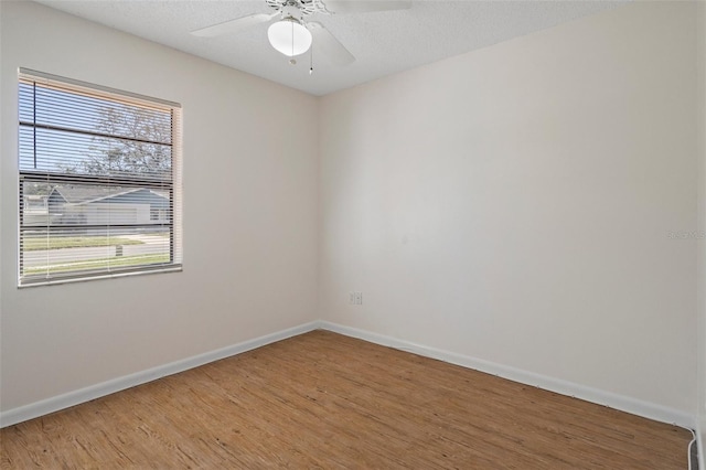 spare room with ceiling fan, wood-type flooring, and a textured ceiling