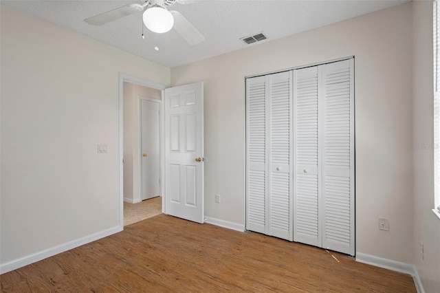 unfurnished bedroom featuring a closet, a textured ceiling, ceiling fan, and light hardwood / wood-style flooring