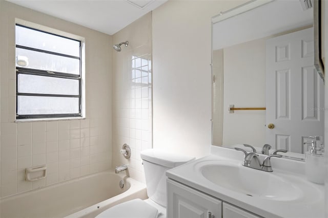 full bathroom featuring tiled shower / bath combo, vanity, and toilet