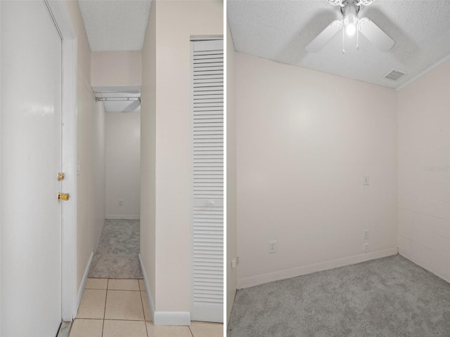 unfurnished bedroom with light tile patterned flooring, ceiling fan, a textured ceiling, and a closet