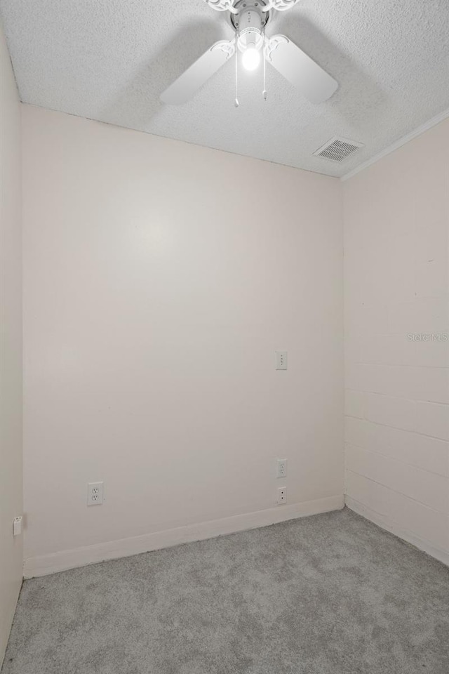 carpeted empty room with ceiling fan and a textured ceiling