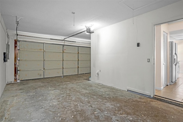 garage featuring a garage door opener, stainless steel fridge, and electric panel