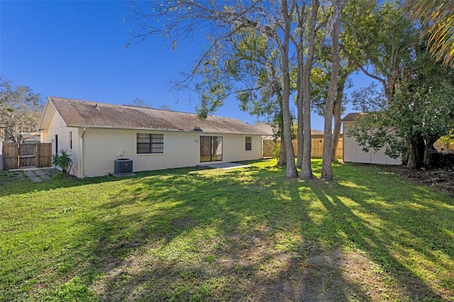 back of property featuring a yard and central air condition unit