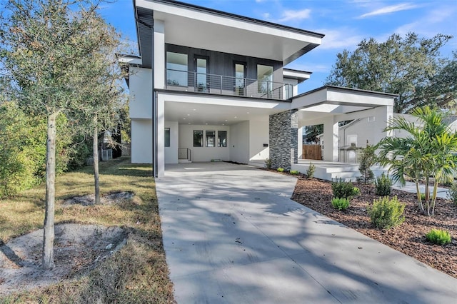 contemporary home featuring a carport and a balcony