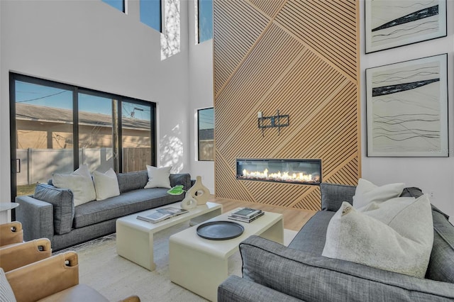 living room featuring a towering ceiling and light hardwood / wood-style flooring