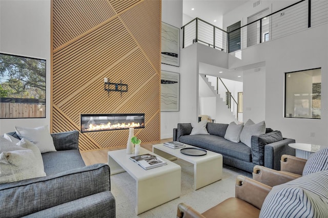 living room featuring hardwood / wood-style flooring and a towering ceiling